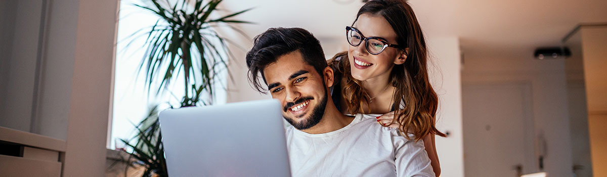 Couple on couch looking at laptop